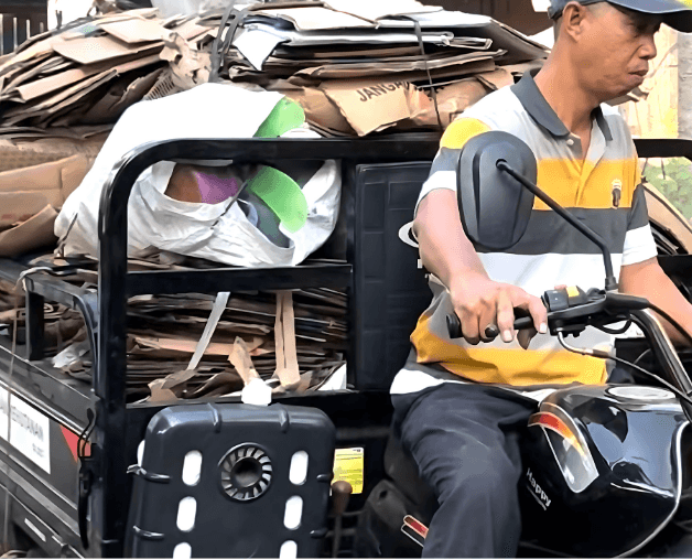 Man on motorbike carrying recyclable waste